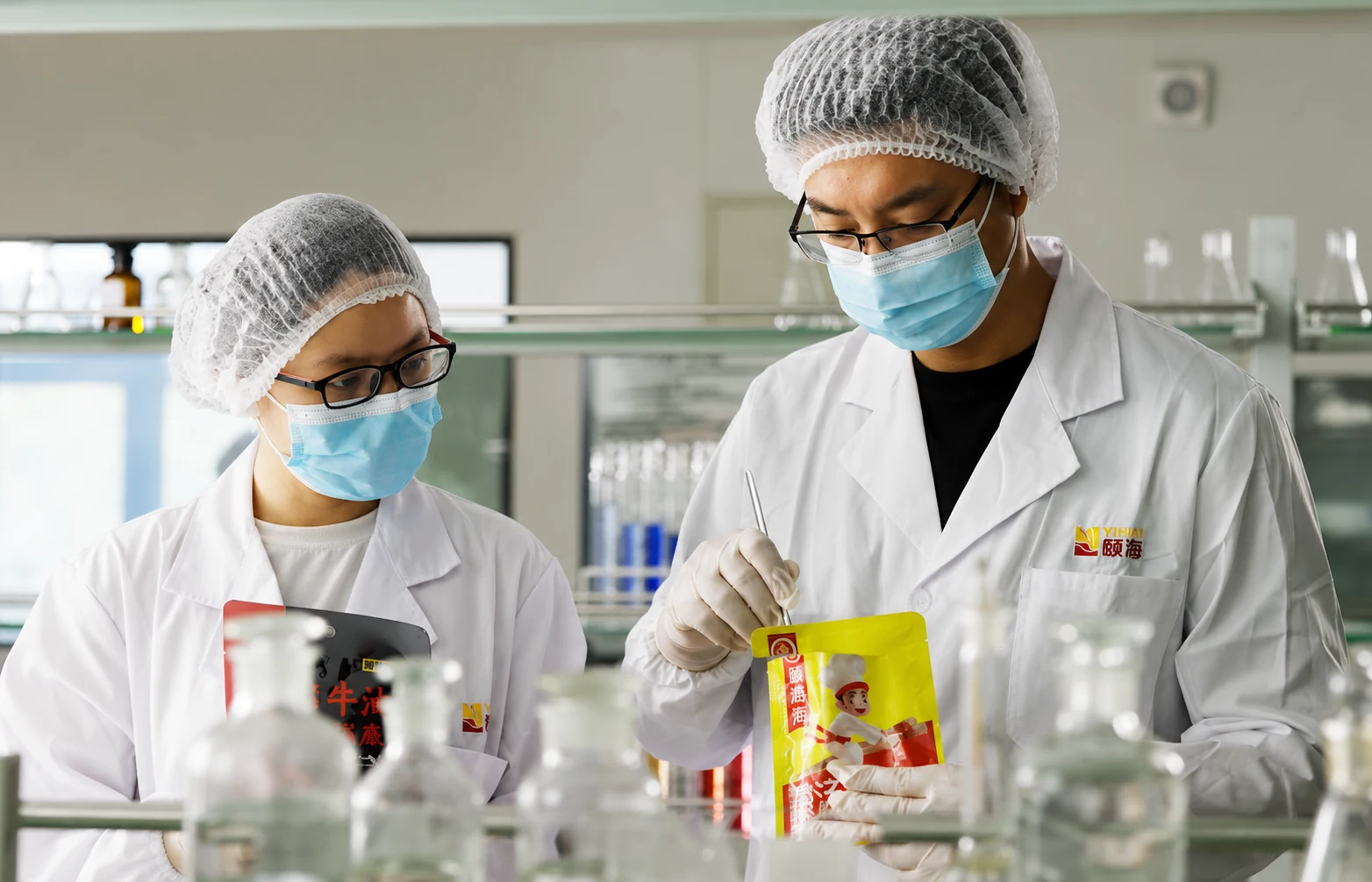 Yihai food specialists reviewing a seasoning sample in a research laboratory